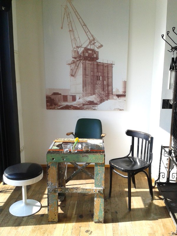 Sitznische mit Kranbild im Hintergrund und altem Tisch