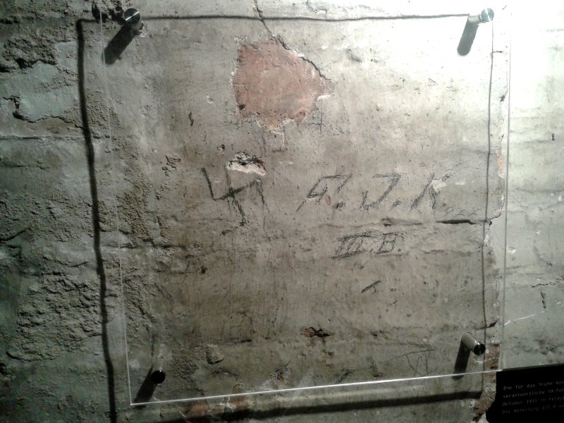 An einer Kellerwand steht mit Bleistift ein Hakenkreuz und FJK 3b
